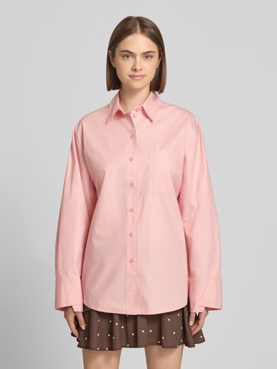 Frauenmodel trägt Oversized Hemdbluse mit Brusttasche Modell 'Demi' von Topshop in Rosa, reine Baumwolle, Ganzkörperansicht von vorne.
