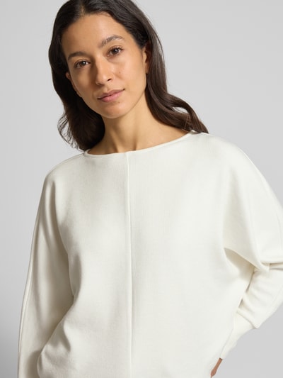 Vrouwenmodel draagt gebreide pullover met boothals, materiaalmix met viscose, los model, Someday Strickpullover met U-Boot-Ausschnitt Modell 'UTIBBY', geribde mouwboorden, kleur wit, ruglengte 54 cm, mouwlengte 60 cm. Close-up van het bovenlichaam.