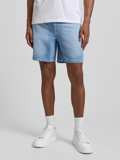 Männermodel trägt Loose Fit Jeansshorts aus Baumwoll-Lyocell-Mix Modell 'ALEX' von SELECTED HOMME, hellblauer Denim, 5-Pocket-Design, Ganzkörperansicht von vorne