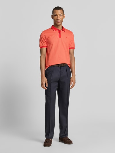 Männermodel trägt Regular Fit Poloshirt mit Logo-Stitching von Lerros in Koralle, Polokragen, Knopfleiste, Ganzkörperansicht von vorne