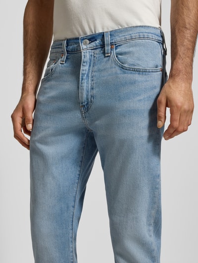 Męski model nosi Tapered Fit Jeans Modell '502™' od Levi's®, jasnoniebieski denim, 5 kieszeni, bawełna z elastanem, zbliżenie na biodra.