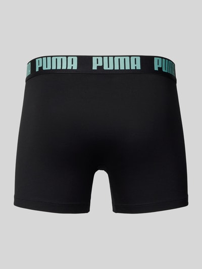 Männermodel trägt Trunks aus Baumwoll-Mix im 2er-Pack von PUMA, schwarze Farbe, elastischer Bund mit Label, Ganzkörperansicht Rückansicht.