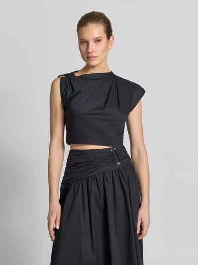 Vrouwenmodel draagt Cropped blouse in asymmetrisch design model 'Dottie' van Forever New van puur katoen met plooien en siergarnering, korte fit, mouwloos, ruglengte maat 36: 39 cm, effen zwart, gladde structuur, Ganzkörperansicht van voren.