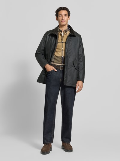 Männermodel trägt Regular Fit Hemd aus reiner Baumwolle von Barbour in Beige mit Karomuster und Knopfverschluss, Ganzkörperansicht von vorne. Herren Freizeithemd von Barbour.