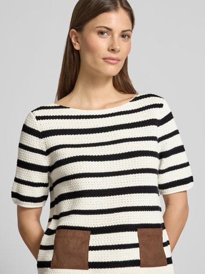 Modelka kobieca nosi Strickshirt mit aufgesetzten Taschen von Oui, mieszanka materiałów z dodatkiem streczu, krój regular fit, okrągły dekolt, nakładane kieszenie, detal z logo, długość tyłu w rozmiarze 36: 52 cm, długość rękawów w rozmiarze 36: 27 cm, pasy czarno-białe, kontrastujące kieszenie, tekstura dzianiny, kolor brązowy i kremowy, zbliżenie na górną część ciała.
