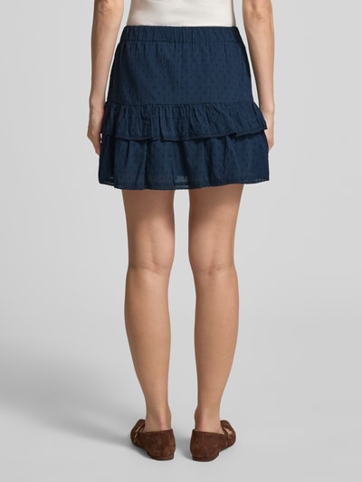 Frauenmodel trägt Volant Mini-Rock aus reiner Baumwolle 'TRINE' von Vero Moda, dunkelblau, gepunktet, Popeline, Ganzkörperansicht Rückansicht.