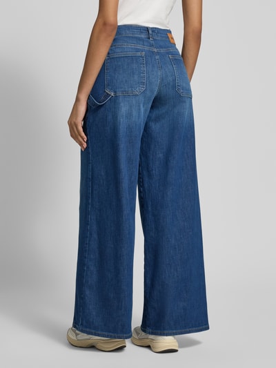 Vrouwenmodel draagt Wide Fit Jeans met opgestikte zakken model 'Liva Urban' van Angels in blauwe katoenmix, 5-pocketmodel, bandwijdte 40 cm, binnenbeenlengte 80 cm, geheel lichaamsaanzicht rugaanzicht.