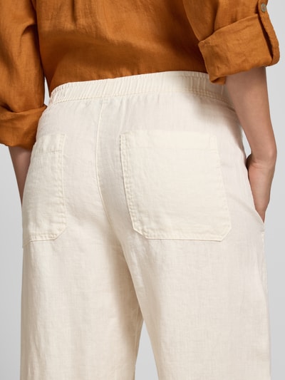 Frauenmodel trägt Leinenhose in verkürzter Passform Modell 'myha linen' von OPUS, cremefarben, strukturierte Oberfläche, Detailaufnahme Rückansicht. Damen Leinenhose, Reines Leinen, Elastischer Bund, Bundweite bei Größe 36: 41 cm, Innenbeinlänge bei Größe 36: 65 cm.