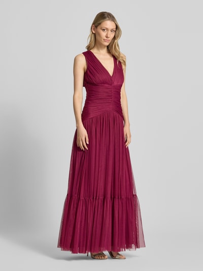 Modelka nosi Maxikleid aus Mesh mit V-Ausschnitt od LACE & BEADS, bordowy tiul, fason A-linia, drapowanie, długość tyłu 150 cm, szerokość w rozmiarze S 40 cm, widok całej sylwetki z przodu.