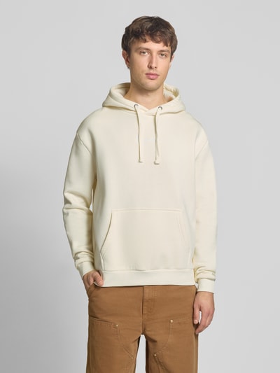 Mannenmodel draagt Relaxed Fit Hoodie met kangoeroezak van KARL KANI van katoenmix, gestikt logo, capuchon met tunnelkoord, elastische boorden, ruglengte maat M 70 cm, mouwlengte maat M 68 cm, geheelbeeld van voren.