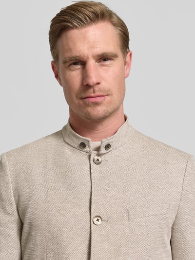 Męski model nosi Slim Fit Sakko mit Stehkragen von Roy Robson, mieszanka bawełny, jasny beż, listwa guzikowa, nakładane kieszenie, zbliżenie górnej części tułowia. Długość tyłu w rozmiarze 50: 76 cm, szerokość ramion w rozmiarze 50: 44 cm, długość rękawów w rozmiarze 50: 68 cm.