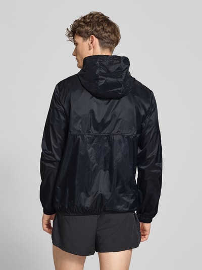 Männermodel trägt schwarze Regular Fit Jacke mit Stehkragen Modell 'Berg' von Ellesse, elastische Abschlüsse, Ganzkörperansicht Rückansicht.