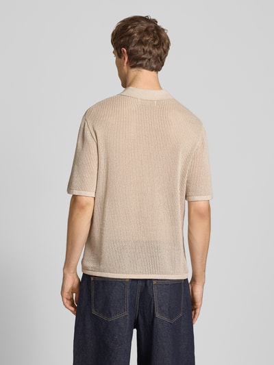 Männermodel trägt Regular Fit Strick-Poloshirt Modell 'CASSIS' von Jack & Jones in Beige, reine Baumwolle, Rückansicht, Ganzkörperansicht.