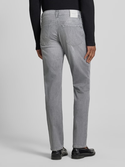 Männermodel trägt Jeans mit Eingrifftaschen Modell 'Chuck' von BRAX, grauer Baumwoll-Elasthan-Mix, Slim-Fit, Ganzkörperansicht Rückansicht.