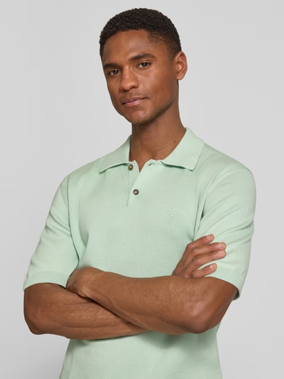 Männermodel trägt Slim Fit Poloshirt aus reiner Bio-Baumwolle von Armedangels, mintgrün, glatt, mit Polokragen, Nahaufnahme Oberkörper.