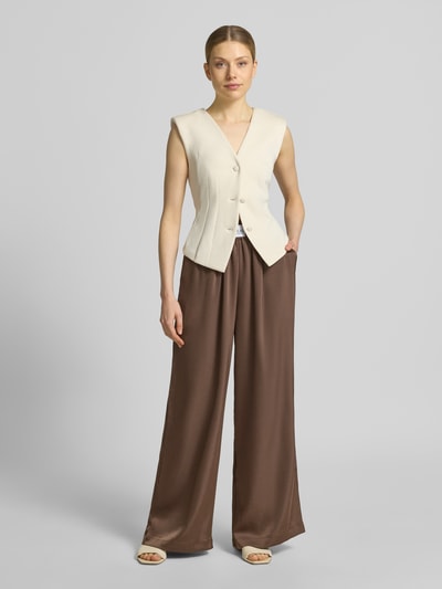 Frauenmodel trägt Wide Leg Stoffhose aus Baumwoll-Mix Modell 'LUCA' von VILLA SOPHIE in Optik: Unifarben, Passform: Wide-Leg-Pants, Applikation: Label-Patch, Bundabschluss: elastisch, seitliche Eingrifftaschen, Ganzkörperansicht von vorne.