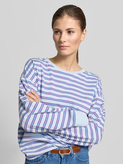 Frauenmodel trägt Longsleeve mit Streifenmuster - curated by Tinvcb von SIC, reine Baumwolle, lockerer Schnitt, Nahaufnahme Oberkörper.