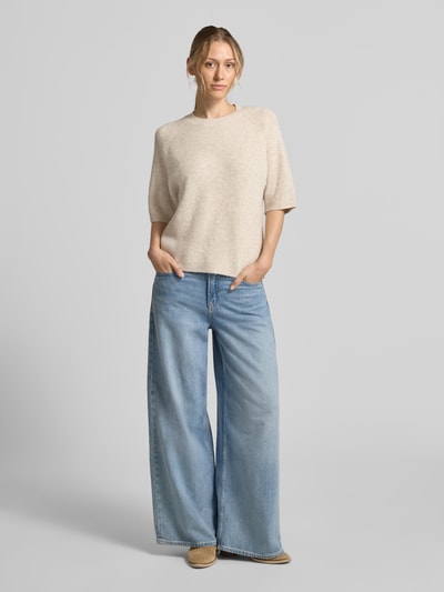 Vrouwenmodel draagt Relaxed Fit T-shirt uit wolmix Model 'Astrid' van FREE/QUENT in tricotlook, lichte beige kleur, 1/2-mouwen, ronde hals, materiaal met elastische materiaalmix met wol, ruglengte bij maat S 57 cm, mouwlengte 28 cm, voorkant volledige lichaamsopname.