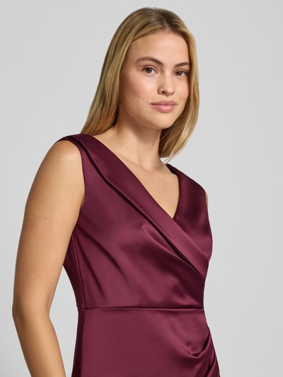 Frauenmodel trägt Abendkleid mit Raffungen von Rinascimento in Satin mit V-Ausschnitt, ärmellos, körpernahe Passform, Nahaufnahme Oberkörper.