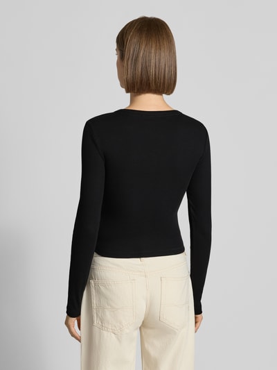 Frauenmodel trägt Slim Fit Longsleeve aus mieszanka bawełny od GUESS, czarny kolor, jednolita faktura, Długość tyłu w rozmiarze S: 44 cm, Ganzkörperansicht Rückansicht.