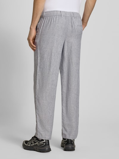 Männermodel draagt Leinenhose mit Bindegürtel Modell 'KARL MYKONOS' van Jack & Jones, mix van linnen en viscose, relaxed fit, strookzak aan de achterkant, knoop- en ritssluiting, strikceintuur, bandwijdte maat M 41 cm, binnenbeenlengte maat M 78 cm, grijs met fijne textuur, ganzkörperansicht rückansicht.