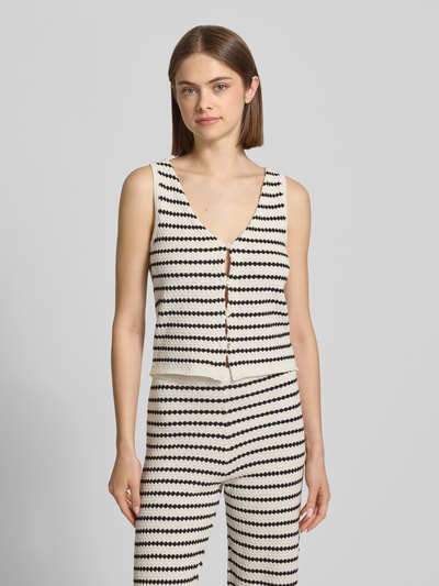 Frauenmodel trägt Strickweste mit V-Ausschnitt und Knopfleiste von REVIEW im Allover-Look aus Material-Mix, Regular-Fit, Ganzkörperansicht von vorne.