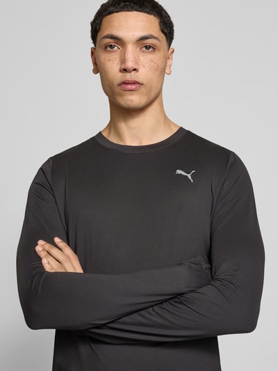 Männermodel trägt Longsleeve mit Logo Modell 'CLOUDSPUN' von PUMA PERFORMANCE in Schwarz, Material-Mix mit Stretch-Anteil, Nahaufnahme Oberkörper. Regular-Fit, Rundhalsausschnitt, Rückenlänge bei Größe M 66 cm.