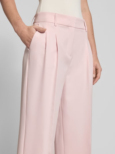 Vrouwenmodel draagt Wide Fit stoffen broek met persplooien van Christian Berg Woman Selection in lichtroze, elastische materiaalmix, steekzakken, haakjes- en ritssluiting, detailopname.