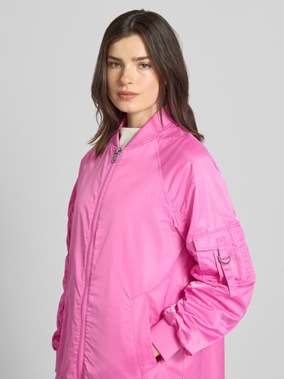 Frauenmodel trägt Regular Fit Jacke mit Stehkragen Modell 'Ali' von Beaumont Amsterdam in Pink mit Raffung, Zweiwege-Reißverschluss, elastischen Ärmelabschlüssen, Eingrifftaschen, Rückenlänge bei Größe 36: 97 cm, Schulterbreite 47 cm, Brustweite 55 cm, Ärmellänge 60 cm, Nahaufnahme Oberkörper.