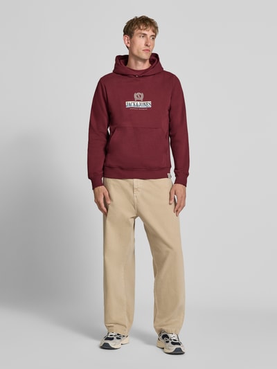 Männermodel trägt Hoodie mit Label-Print Modell 'FREDERIKSBERG' von JACK & JONES, lockerer Schnitt, Baumwoll-Mix, Ganzkörperansicht von vorne.