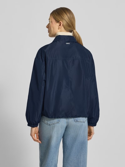 Frauenmodel trägt Jacke mit Pattentaschen Modell 'CICAMI' von CINQUE in Dunkelblau, glatte Textur, Ganzkörperansicht Rückansicht. Regular Fit, Umlegekragen, Reißverschluss, Rückenlänge bei Größe 36 ca. 58 cm, Schulterbreite 50 cm, Brustweite 56 cm, Ärmellänge 59 cm.