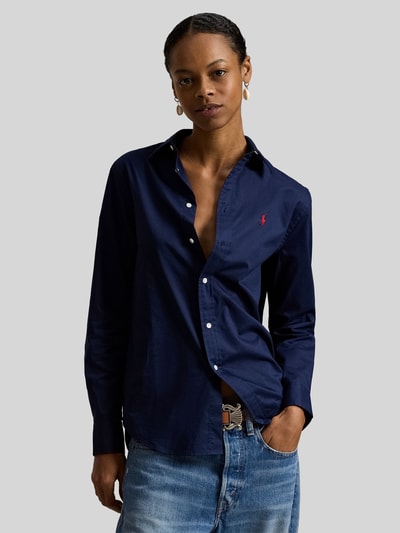 Frauenmodel trägt Slim Fit Hemdbluse aus reiner Baumwolle von Polo Ralph Lauren, Optik: Unifarben, Passform: Slim-Fit, Hemdkragen, Rückenpasse mit Cacharel-Falte, einreihige Knopfleiste, Ärmelabschluss Manschette, Rumpfabschluss abgerundet, Material: reine Baumwolle, dunkelblau, glatte Textur, Ganzkörperansicht von vorne.