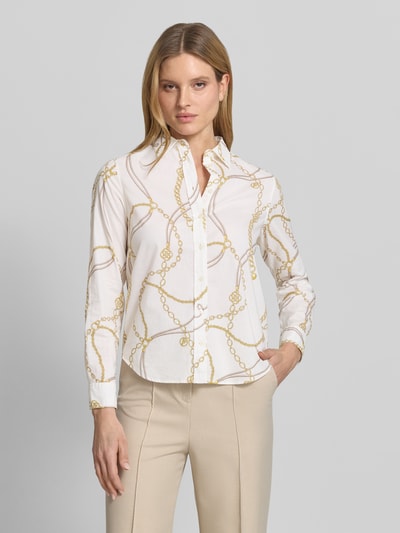 Frauenmodel trägt Regular Fit Bluse im Allover-Look von Gant in Weiß mit goldfarbenem Kettenmuster, reine Baumwolle, Nahaufnahme Oberkörper.