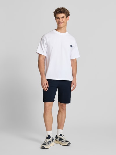 Männermodel trägt Sweatshorts mit elastischem Bund Modell 'KARLOS' von Blend aus Baumwoll-Mix, Regular-Fit, dunkelblau, Ganzkörperansicht von vorne.