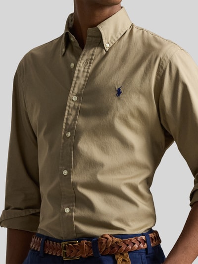 Męski model nosi Regular Fit Freizeithemd aus reiner Baumwolle od Polo Ralph Lauren, efekt: jednolity kolor, krój regular fit, kołnierzyk typu button down, listwa guzikowa na całej długości, wyhaftowane logo, zapięcie na guzik, długi rękaw, sportowy mankiet, splot twill, bawełna; zbliżenie na górną część ciała.