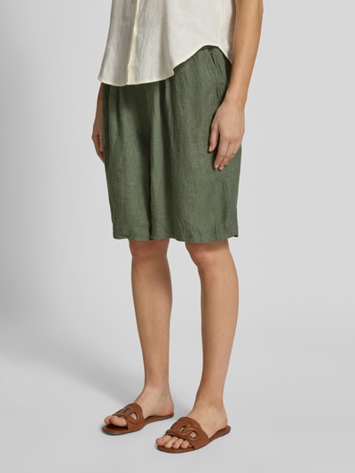 Kobiece modelka nosi Wide Leg Leinenshorts mit Bundfalten od s.Oliver RED LABEL, zielony jednolity len, boczne i tylne kieszenie, widok całej sylwetki z przodu.