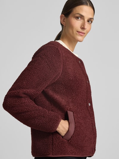 Frauenmodel trägt Regular Fit Jacke mit Strukturmuster Modell 'Selma' von Didriksons in Dunkelrot, Eingrifftaschen, Nahaufnahme Oberkörper. Rückenlänge 59 cm, Schulterbreite 36 cm, Brustweite 50 cm, Ärmellänge 65 cm.