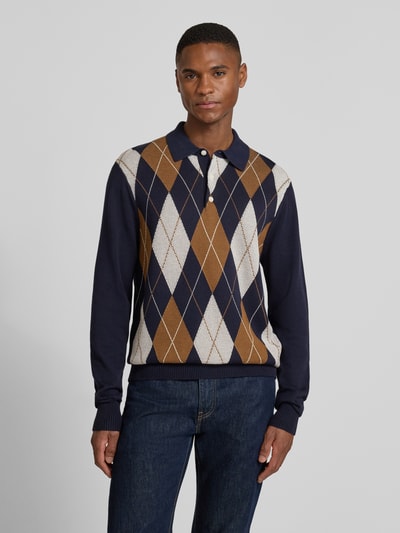 Męski model nosi Regular Fit Strickpullover aus reiner Baumwolle od Tommy Hilfiger, niebieski sweter w kratę, dzianina, widok z przodu, ujęcie całej sylwetki.