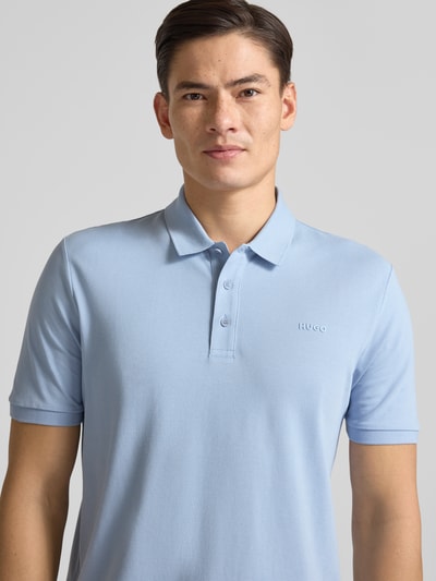 Männermodel trägt Regular Fit Poloshirt aus reiner Baumwolle Modell 'DONOS222' von HUGO in Hellblau, unifarben, Nahaufnahme Oberkörper.