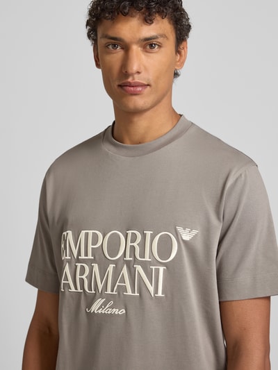 Männermodel trägt T-Shirt mit Label-Stitching von Emporio Armani in Grau, reine Baumwolle, Regular-Fit, Nahaufnahme Oberkörper.