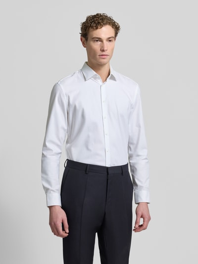 Męski model nosi Super Slim Fit Businesshemd mit Kentkragen od Jake*s, jednokolorowa, kołnierzyk typu kent, mieszanka bawełny i elastanu, fason slim fit, długość tyłu 77 cm, szerokość ramion 45 cm, długość rękawów 65 cm, sportowe mankiety, listwa guzikowa na całej długości, zaokrąglony dół, łatwa pielęgnacja, ujęcie: całopostaciowe z przodu.