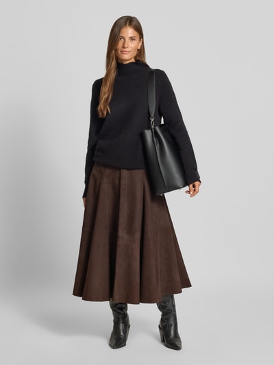 Frauenmodel trägt braunen Midirock aus echtem Leder Modell 'Kilar' von Cph Muse, A-Linie, sichtbar strukturierte Oberfläche, Ganzkörperansicht von vorne, Bundweite 38 cm, Länge 84 cm.