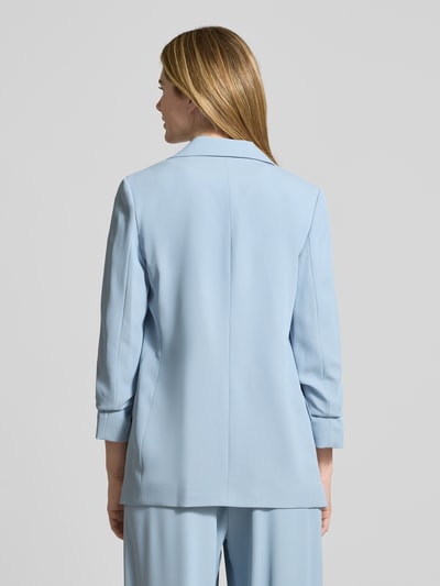 Frauenmodel trägt Relaxed Fit Blazer mit Pattentaschen von Jake*s Collection in Hellblau, Material-Mix mit Stretch-Anteil, Rückenlänge 69 cm, Brustweite 46 cm, Ärmellänge 52 cm, Reverskragen, Ganzkörperansicht Rückansicht.