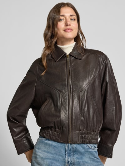 Frauenmodel trägt Lederjacke mit Reißverschluss Modell 'PATNEY' von DRYKORN, Echtleder, Regular Fit, dunkles Braun, Nahaufnahme Oberkörper.