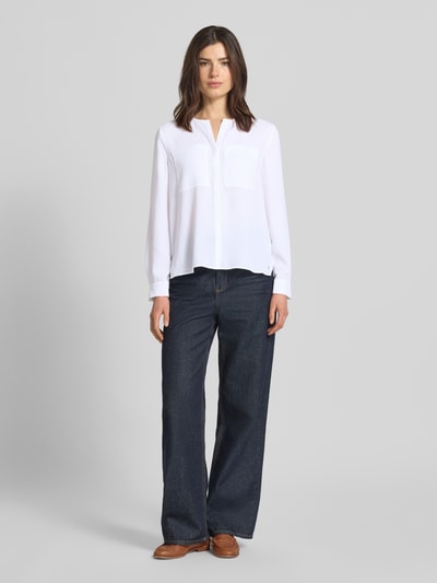 Frauenmodel trägt Regular Fit Bluse mit Brusttaschen von Marc Cain, weiß, gerade Passform, Tunika-Ausschnitt, Ganzkörperansicht von vorne.