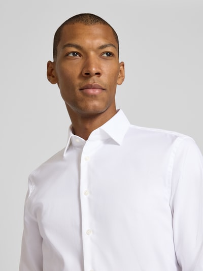 Männermodel trägt weißes Slim Fit Businesshemd aus Baumwoll-Mix von Jake*s, glatte Textur, Nahaufnahme Oberkörper.