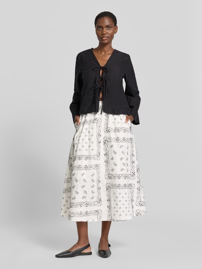 Frauenmodel trägt ausgestellten Maxi-Rock aus reiner Baumwolle Modell 'CARAVAN' von Weekend Max Mara, Allover-Muster auf weißer Popeline, elastischer Bund, Ganzkörperansicht von vorne.