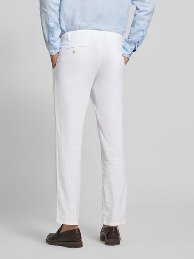 Męski model nosi Hose aus Leinen-Viskose-Mix mit Eingrifftaschen von Christian Berg Men, białe spodnie, krój regular fit, długość wewnętrzna nogawki 78 cm, szerokość w rozmiarze 50: 47 cm, zapięcie na guzik i zamek błyskawiczny, wpuszczane kieszenie, mieszanka lnu i wiskozy, widok całej sylwetki z tyłu.