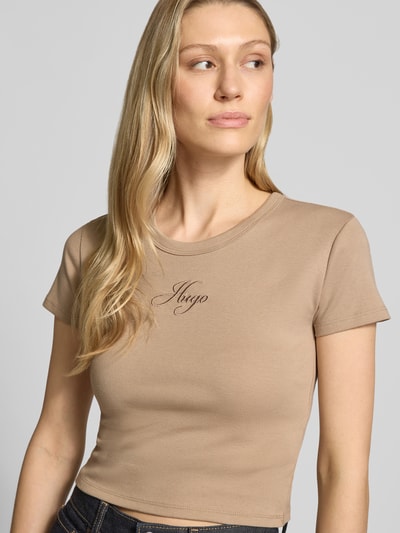 Kobiece modelka nosi damski t-shirt Slim Fit T-Shirt aus Baumwoll-Mix Modell 'DELANOR' von HUGO, efekt: jednolity kolor, mieszanka bawełny, okrągły dekolt, krótki rękaw, wyhaftowane logo, dżersej, ganzkörperansicht z przodu