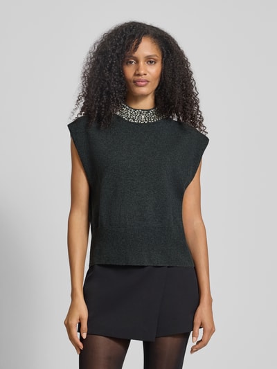Frauenmodel trägt Stricktop mit Stehkragen und Ziersteinbesatz von Gestuz, Material-Mix mit Stretch-Anteil, Regular-Fit, Kappärmel, dunkler Farbton, glatte Textur, Ganzkörperansicht von vorne.